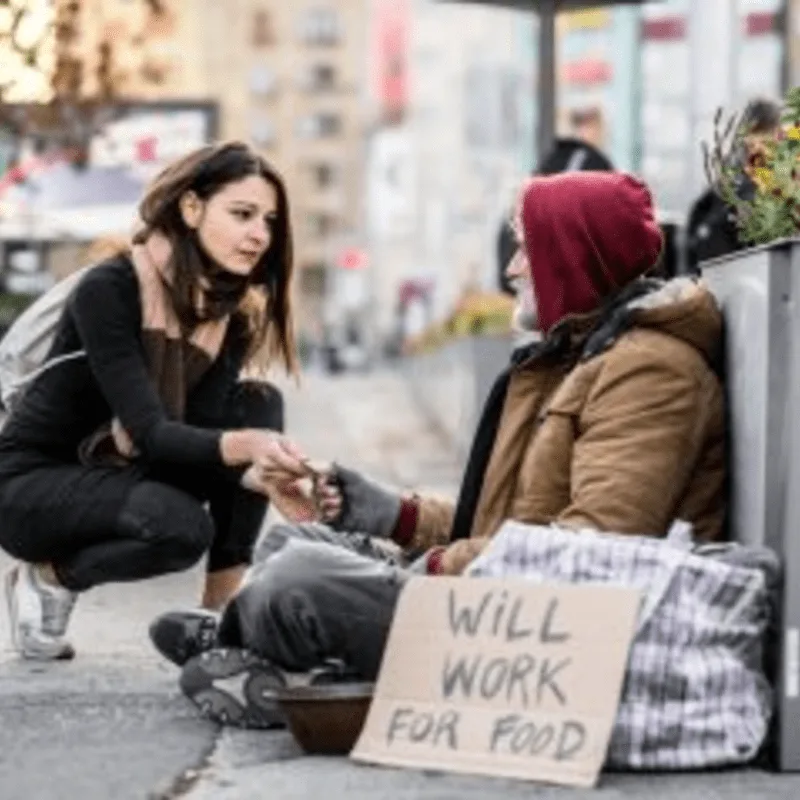 A volunteer offering support and dignity to a neighbor experiencing homelessness